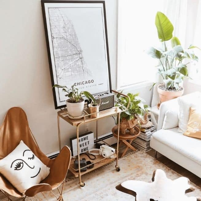 Bar cart in a boho room with plants as accessories, and a custom poster of chicago