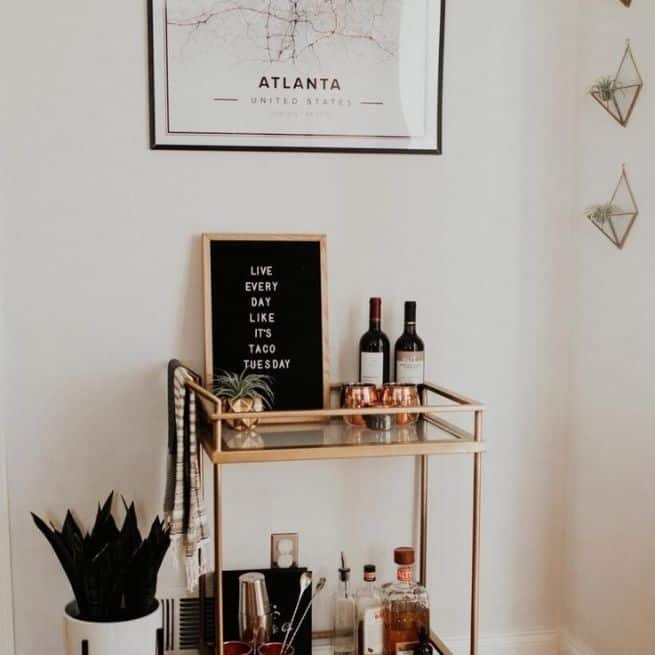 Bronze cart holding wine, accessorised with a custom poster of Atlanta